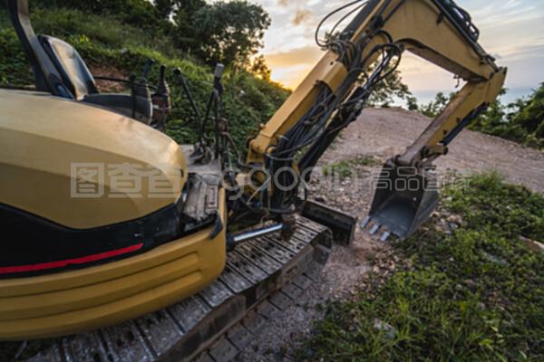 在日落天空的建筑工地上的现代挖掘机。