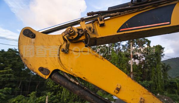 在日落天空的建筑工地上的现代挖掘机的详细资料。